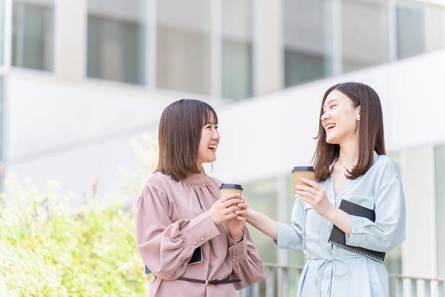 コーヒーを持って雑談する同僚・友達