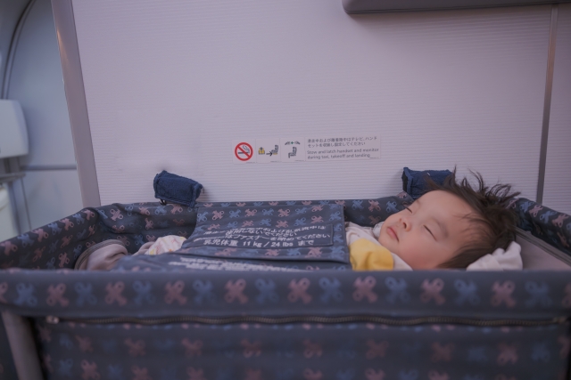 飛行機内のバシネットで眠る赤ちゃん