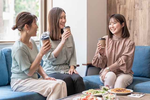 カフェでコーヒーを飲みながら会話する女性